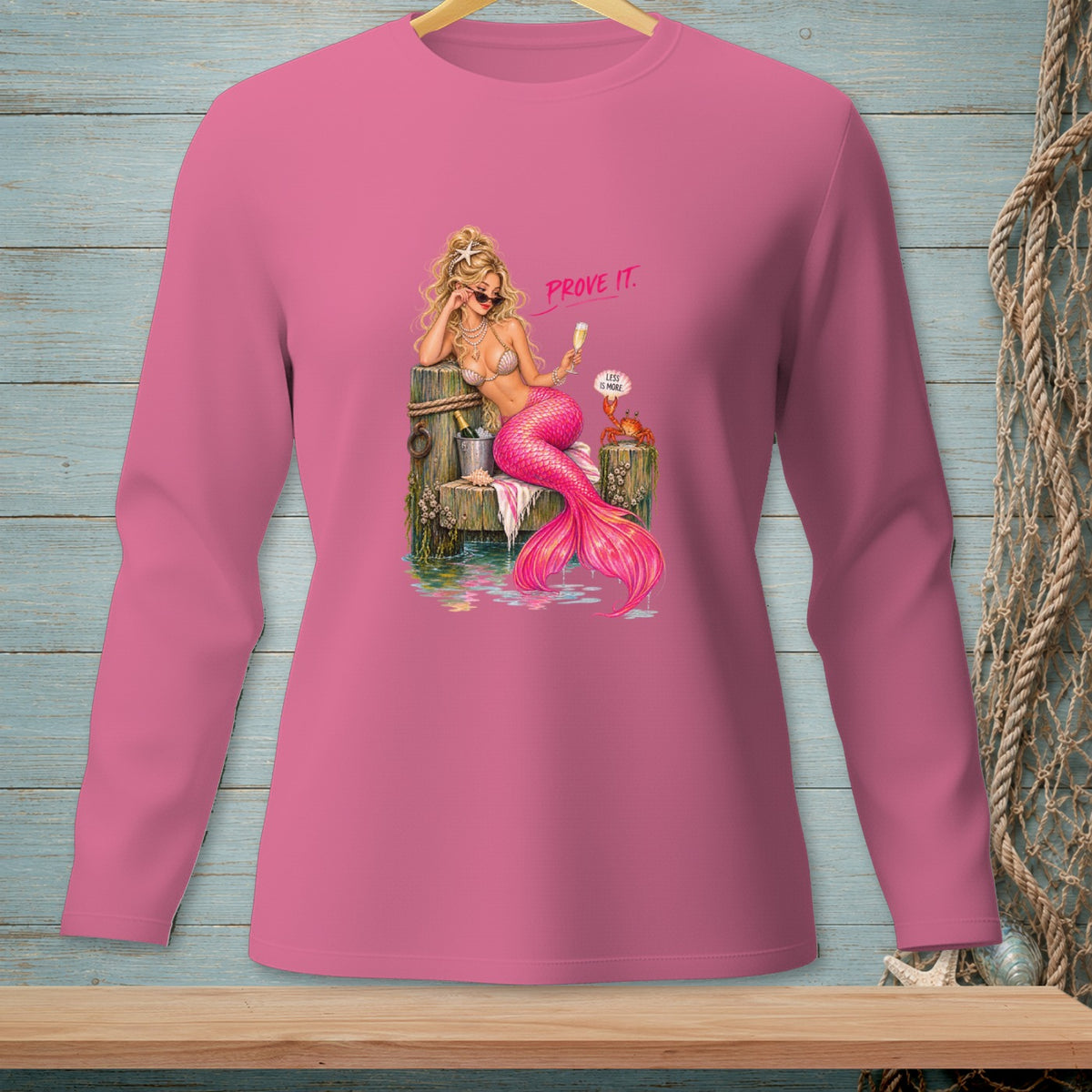 Pink long-sleeve shirt with graphic of a mermaid holding champagne and a crab reading "Less is More."