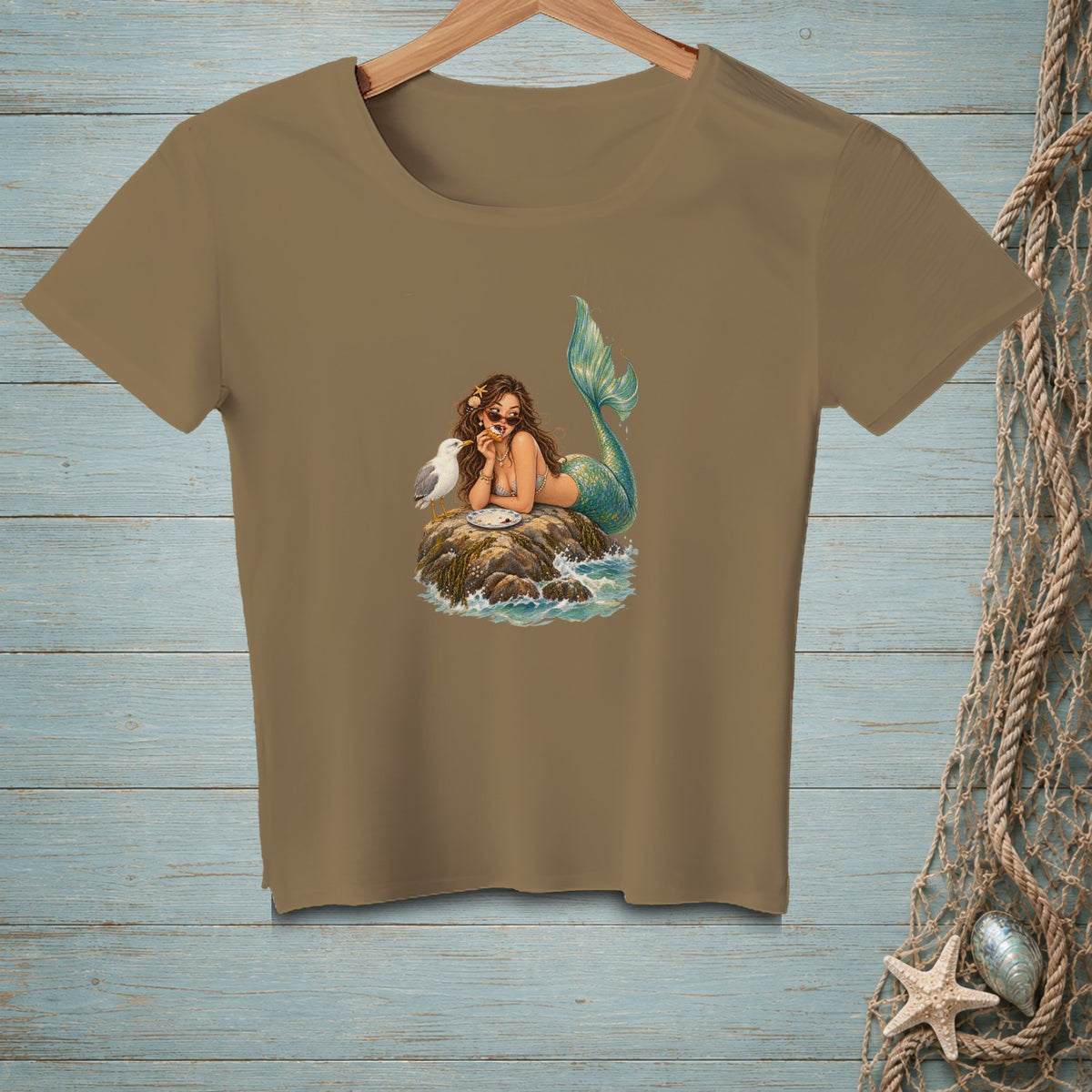 T-shirt with graphic of mermaid eating with seagull on a rock.