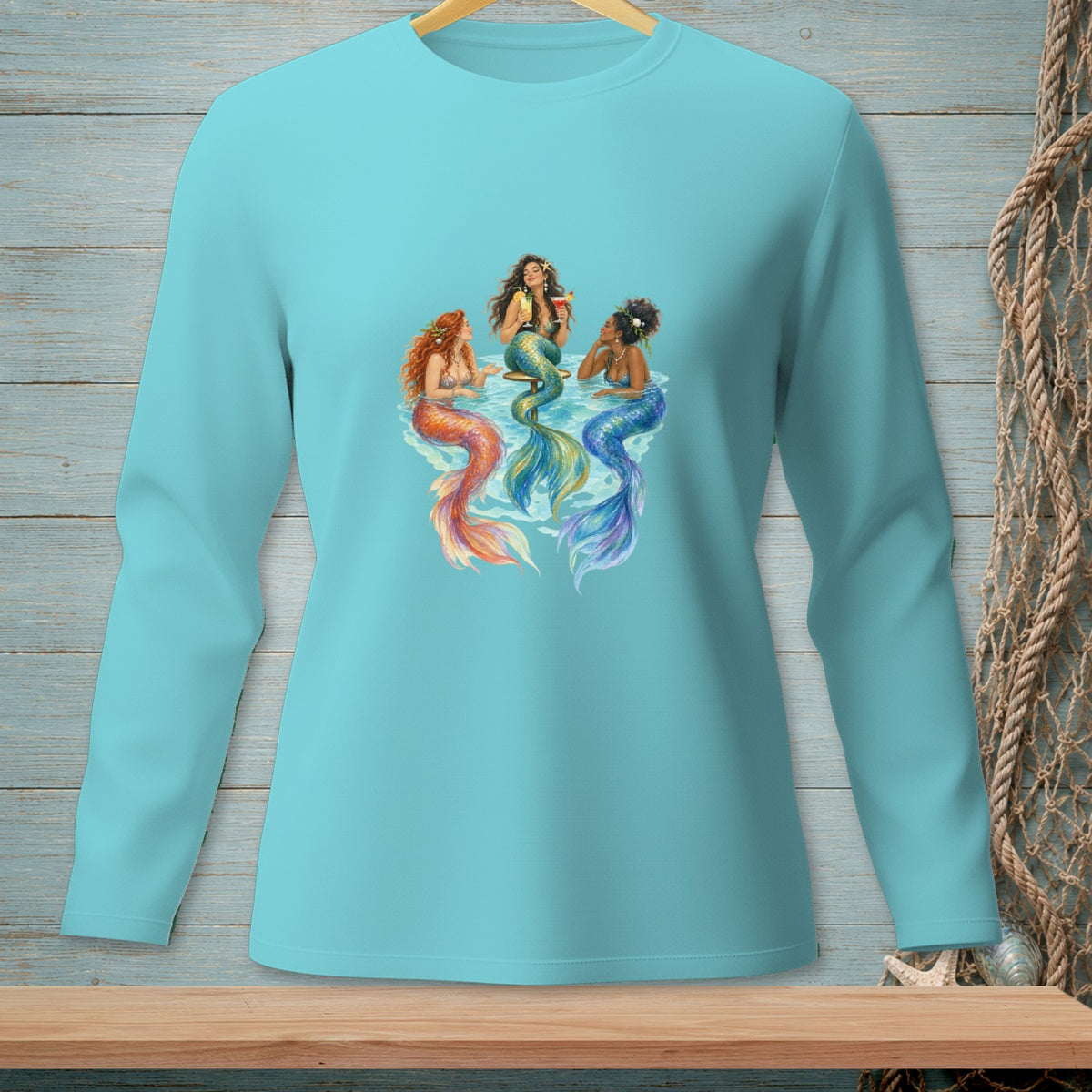 Three mermaids with colorful tails relax in water, one holding a drink.