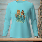 Two mermaids with shimmering tails sit on a wooden dock, holding glasses and a bottle.