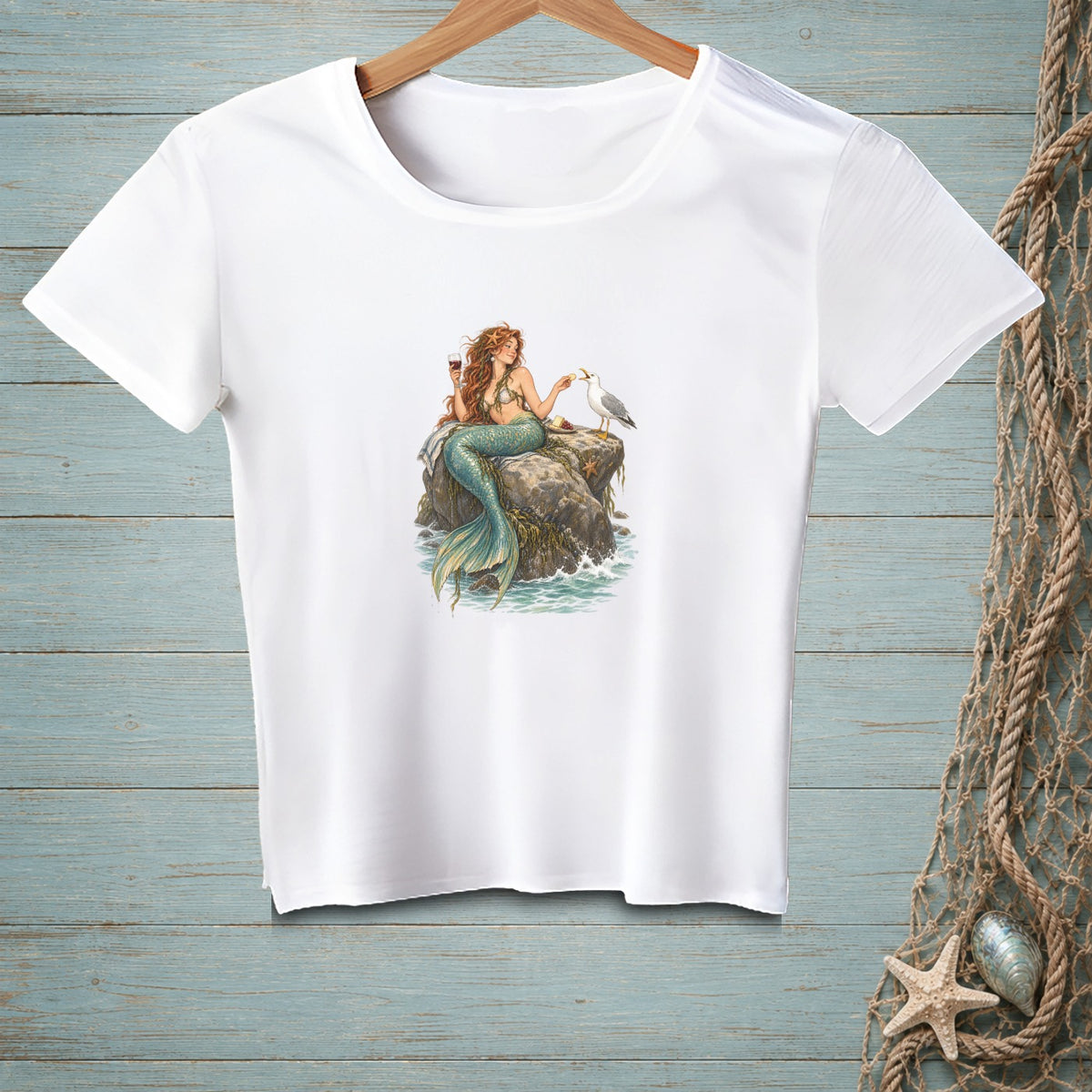 White t-shirt with a graphic of a mermaid holding wine and feeding a seagull.
