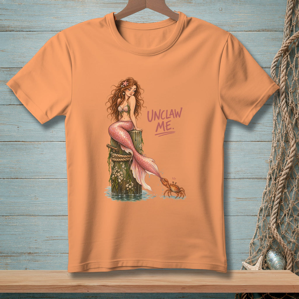 Orange t-shirt with mermaid and crab graphic and "UNCLAW ME." text.