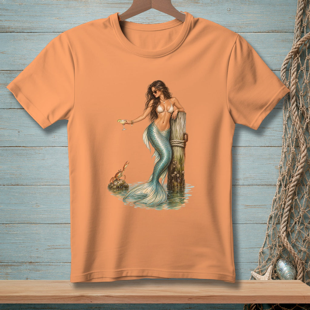 Orange t-shirt with a detailed illustration of a mermaid holding a drink by a weathered post.