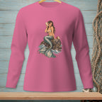 Pink long-sleeve shirt with a mermaid sitting on a rock by the sea.
