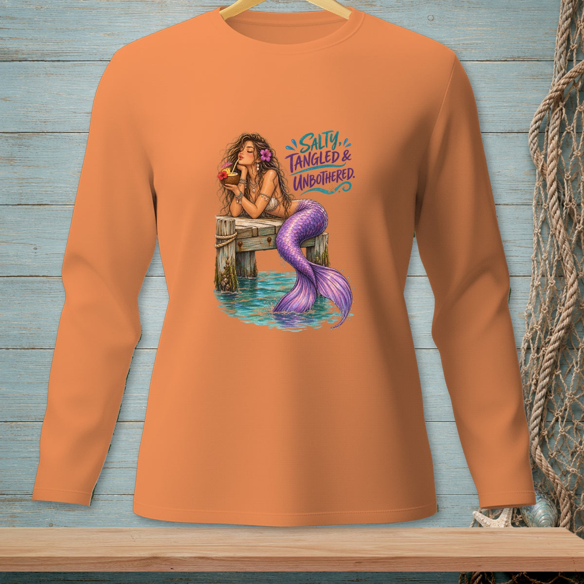 Mermaid with purple tail on pier, holding drink, text "SALTY, TANGLED & UNBOTHERED."