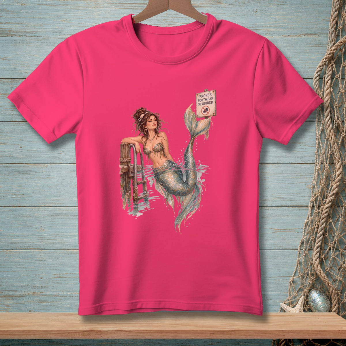 Pink t-shirt with mermaid graphic and "Proper Footwear Required" sign.
