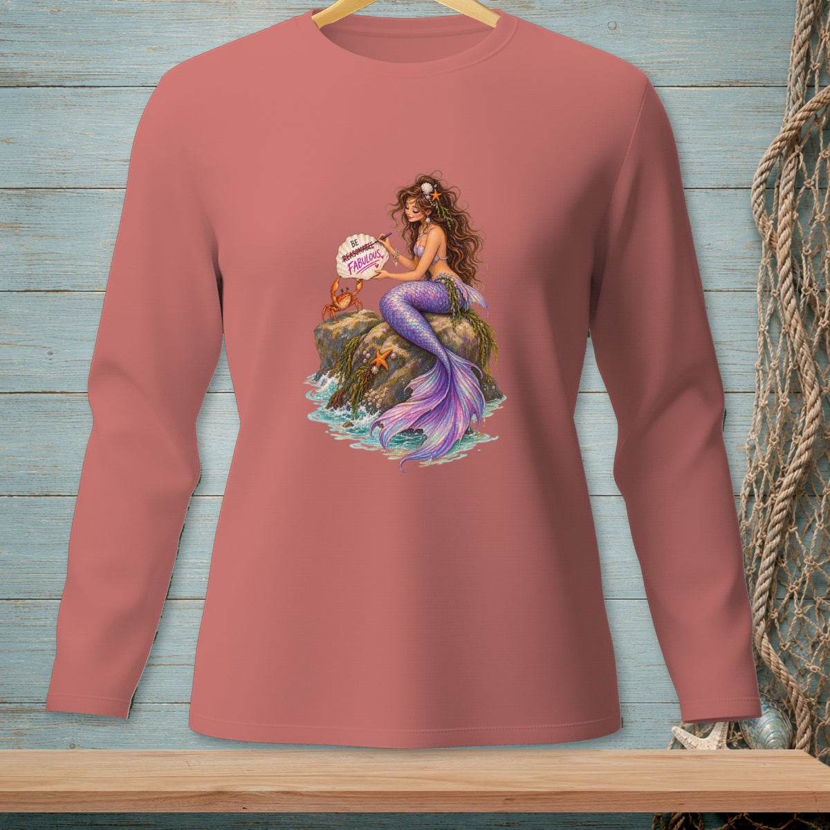 Mermaid sitting on rocks with crab and starfish, holding a sign reading "Be Reasonable. Be Fabulous."