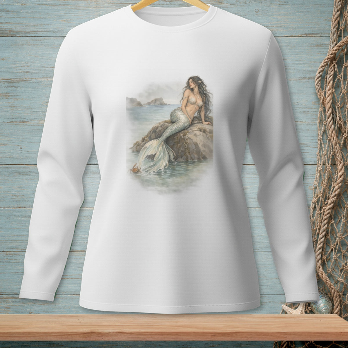 White long-sleeve shirt with a mermaid sitting on a rock in the ocean.