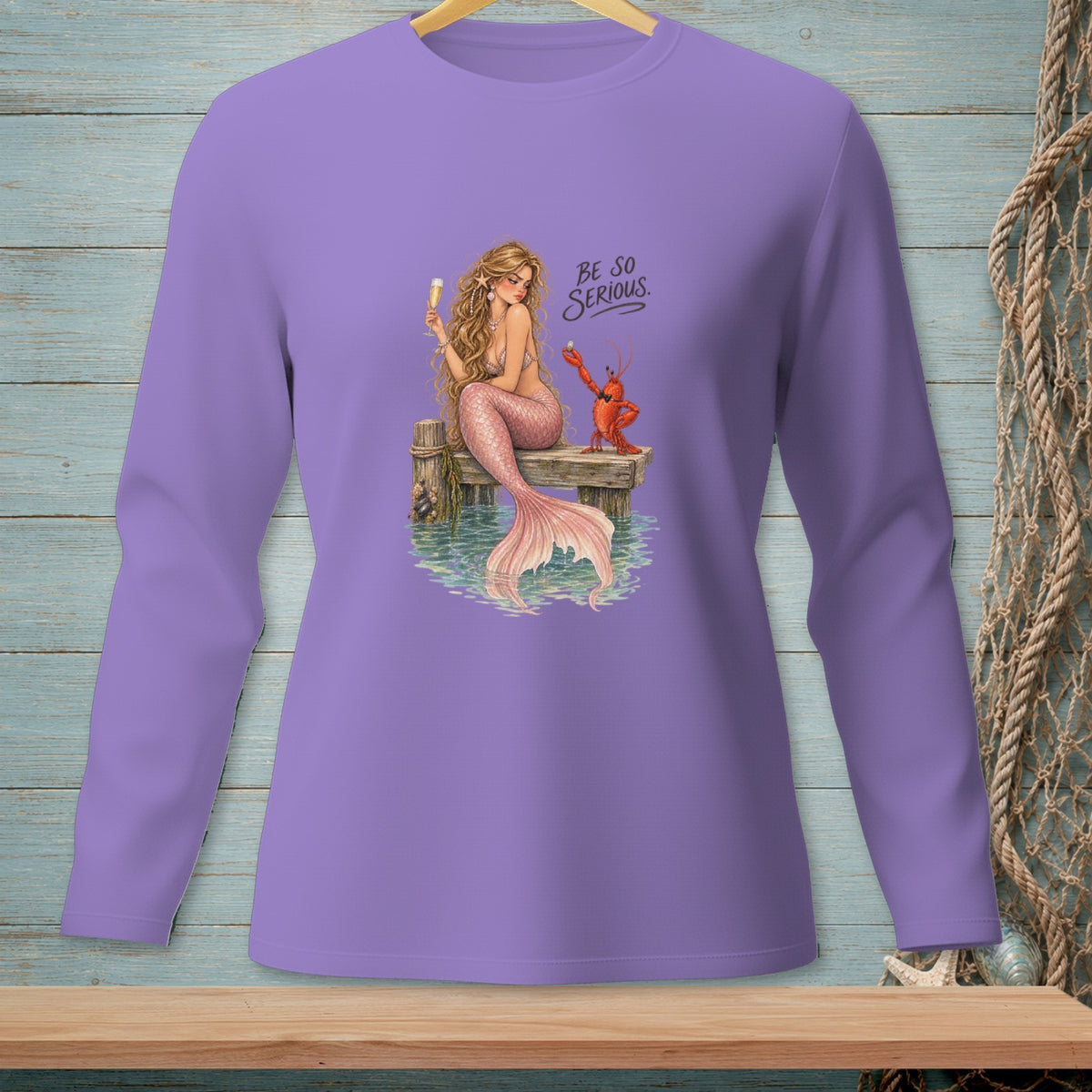 Purple long-sleeve shirt with a mermaid holding a drink and a lobster, text reads "BE SO SERIOUS."