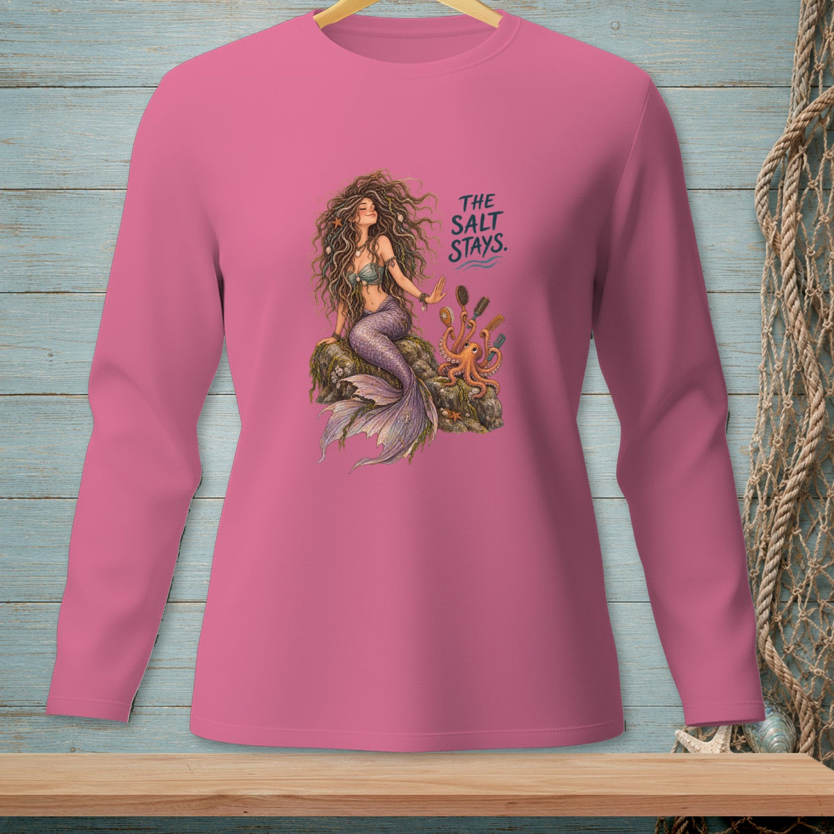 Pink long sleeve shirt with a mermaid, octopus, combs, and text "THE SALT STAYS."