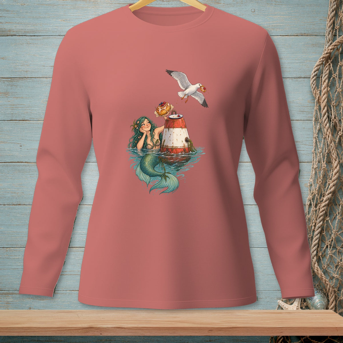 Mermaid by buoy with seagull carrying food, shown on a coral long-sleeve shirt.