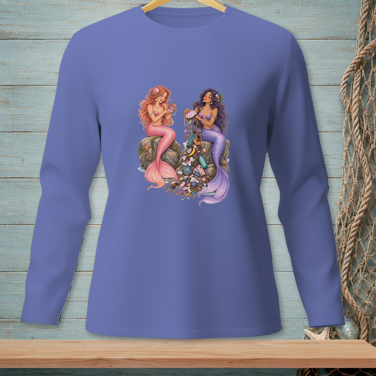 Two mermaids sit on a rock, surrounded by a pile of trash and jewelry.