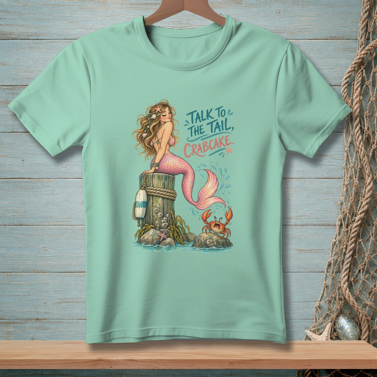 Mint t-shirt graphic of a mermaid and crab with text "Talk to the Tail, Crabcake".