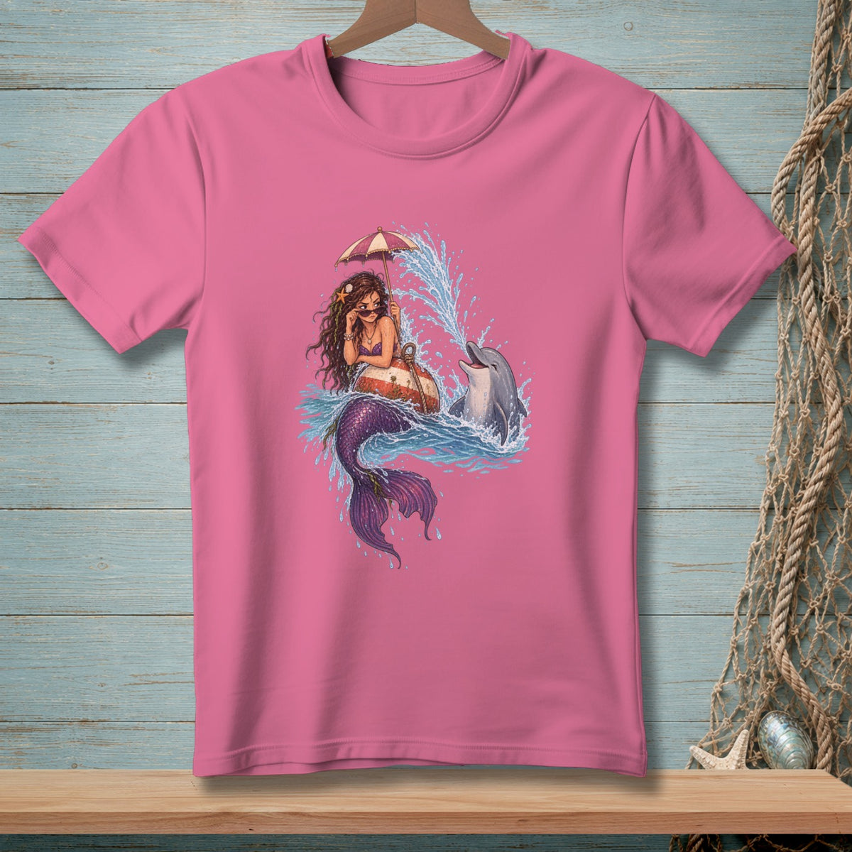 Mermaid under an umbrella with a dolphin splashing in water.