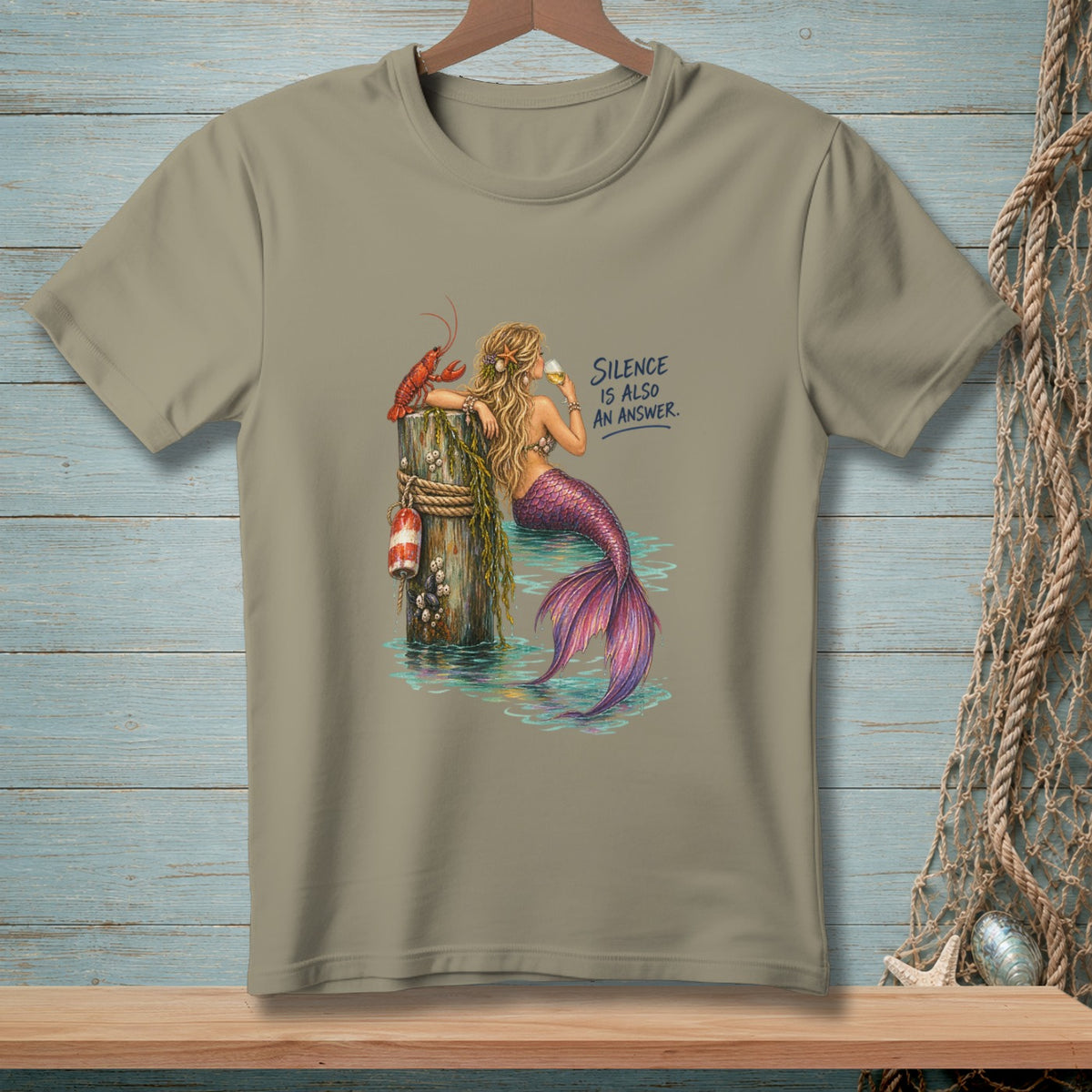 Mermaid with lobster on pier, drinking wine. Text reads "SILENCE IS ALSO AN ANSWER."