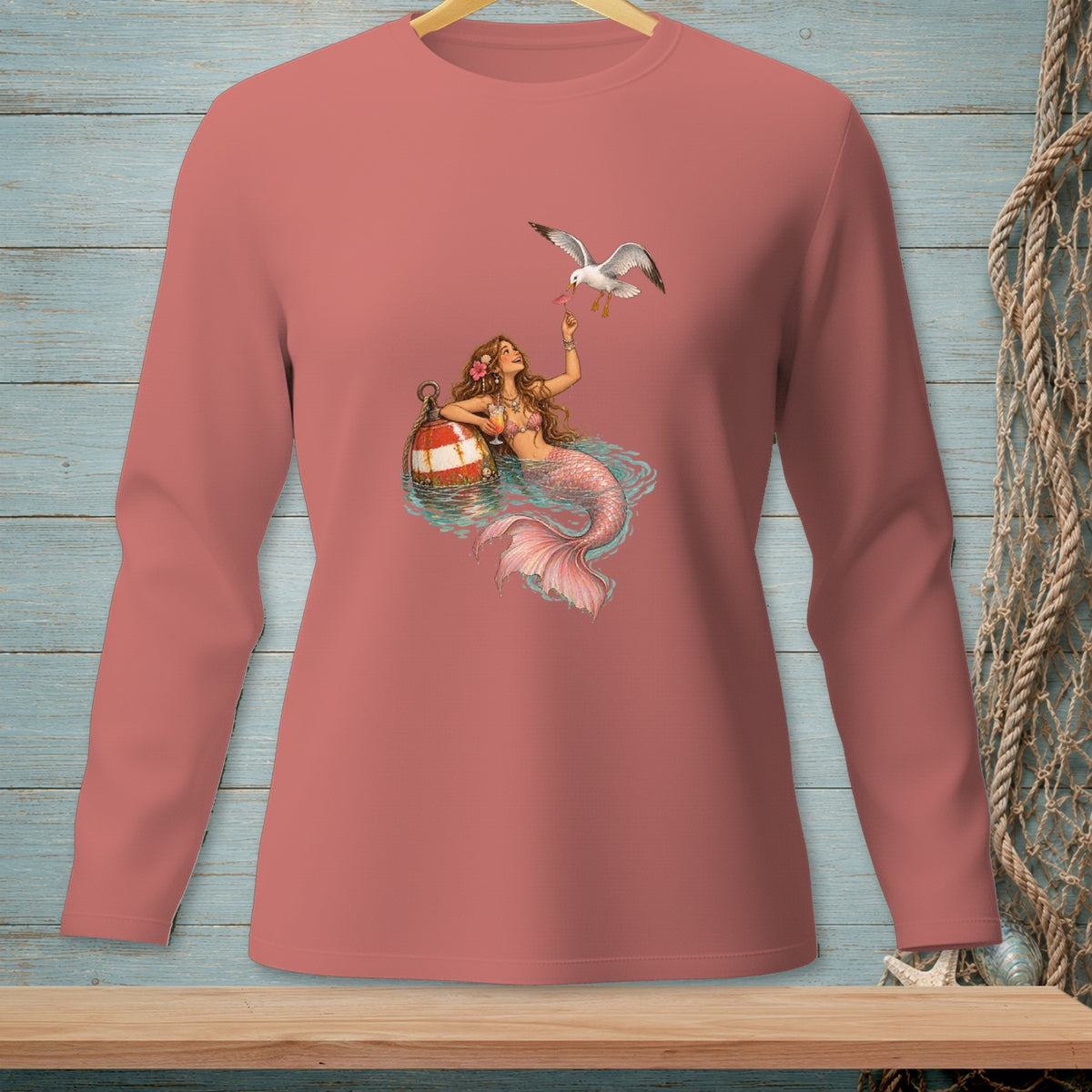 Long-sleeve shirt with a mermaid feeding a seagull a pink item.