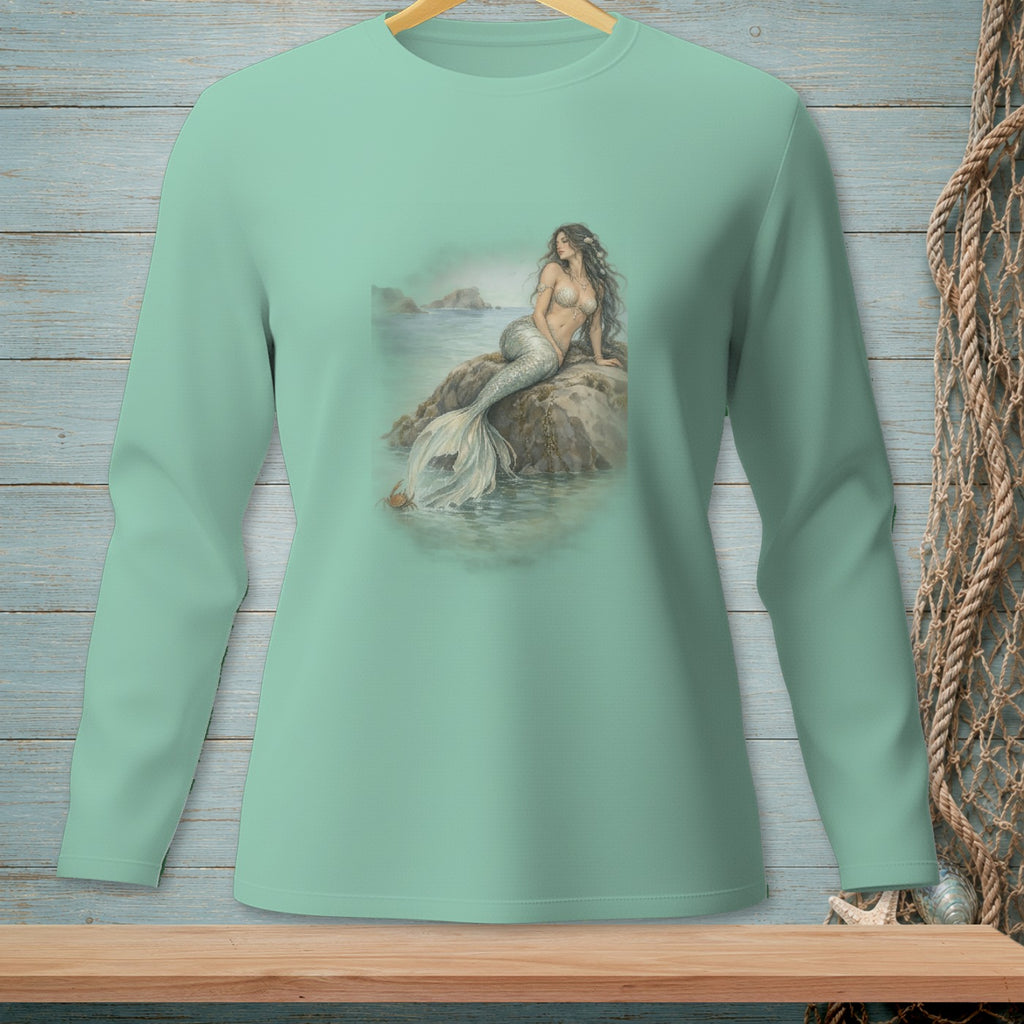 Long-sleeve teal shirt with a mermaid sitting on a rock near the water.