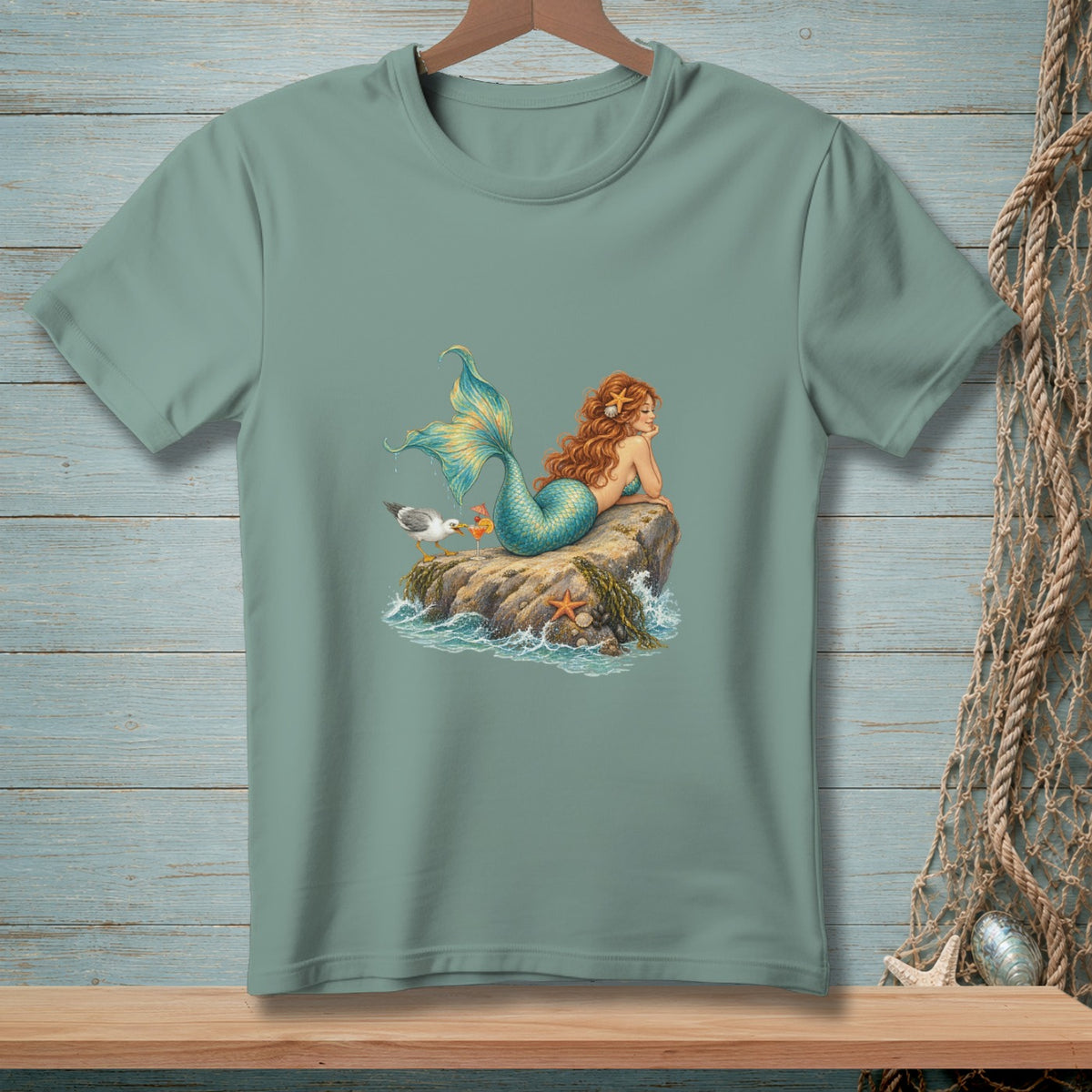 T-shirt with a mermaid relaxing on a rock with a seagull and drinks.