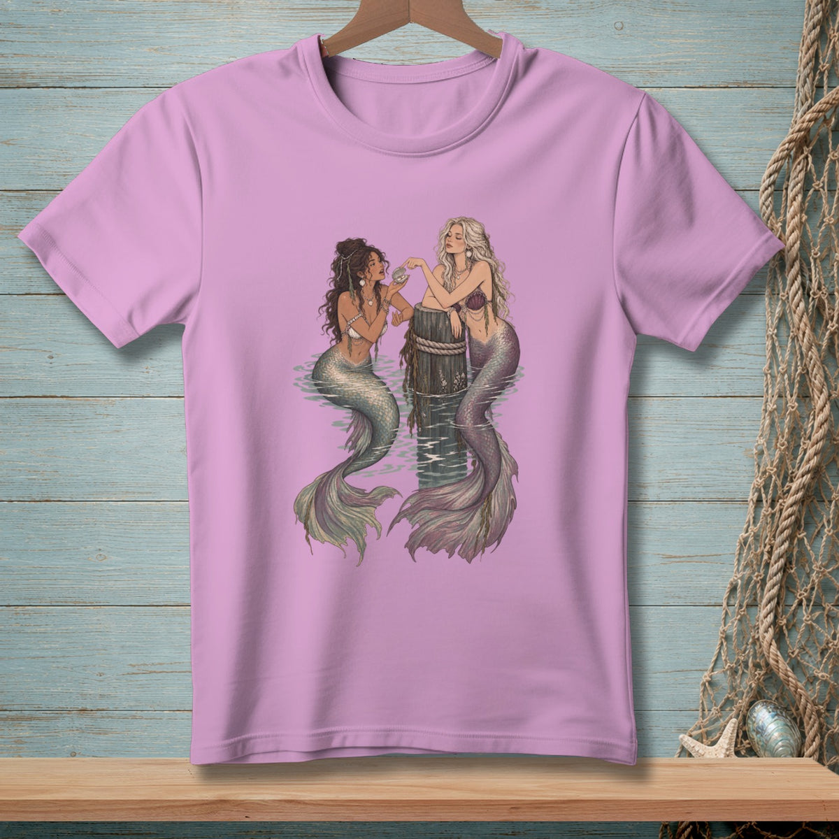 Two mermaids sit in water next to a wooden post, one holding a pearl.