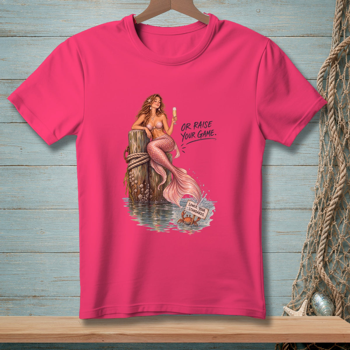 Pink t-shirt with mermaid on a post and text "OR RAISE YOUR GAME."