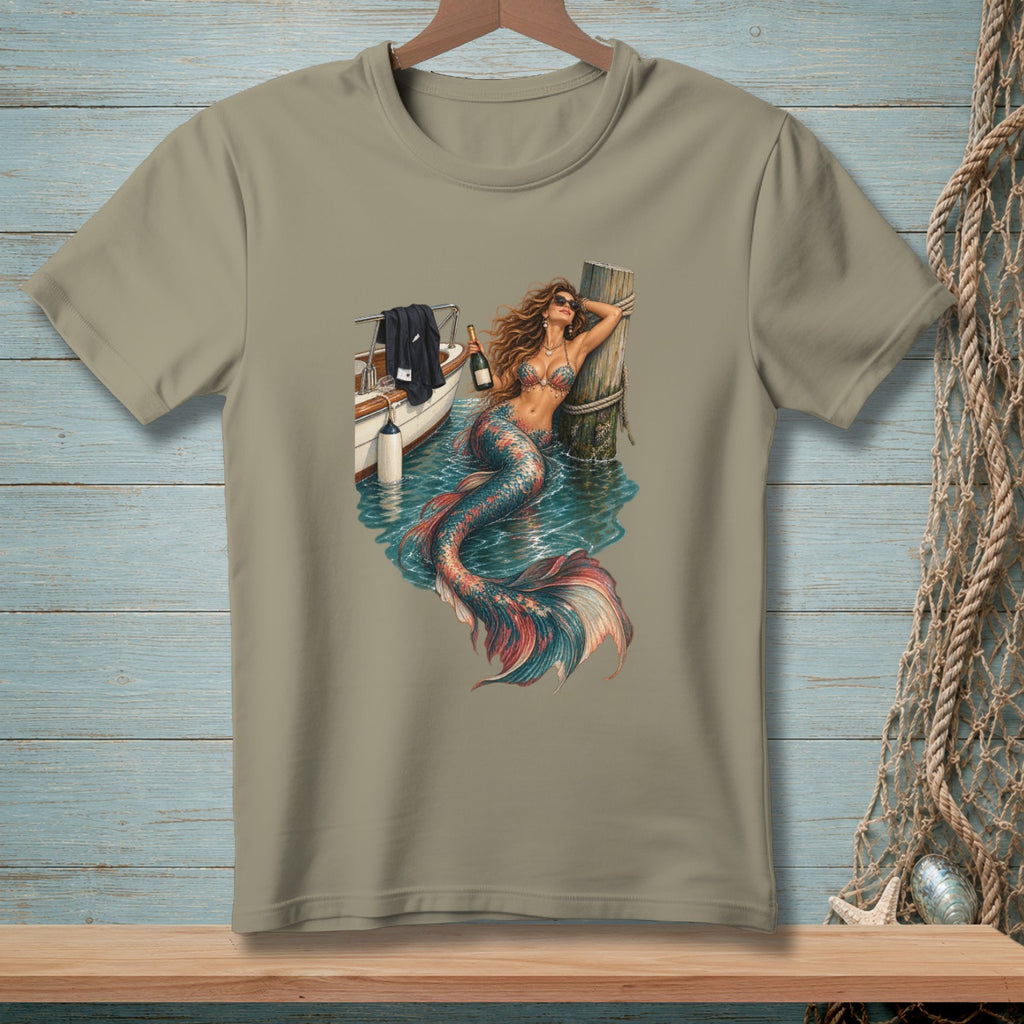 T-shirt with a mermaid wearing sunglasses leaning on a post by a boat.