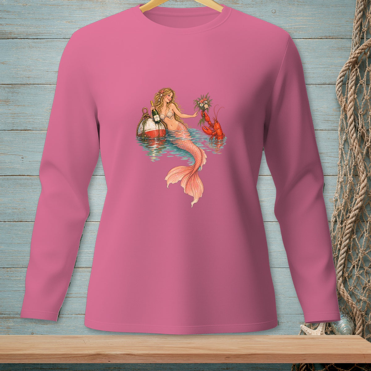 Pink long-sleeve shirt with mermaid, lobster, and champagne bottle graphic.