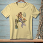 Light yellow t-shirt with a mermaid pouring champagne next to a crab, with text.