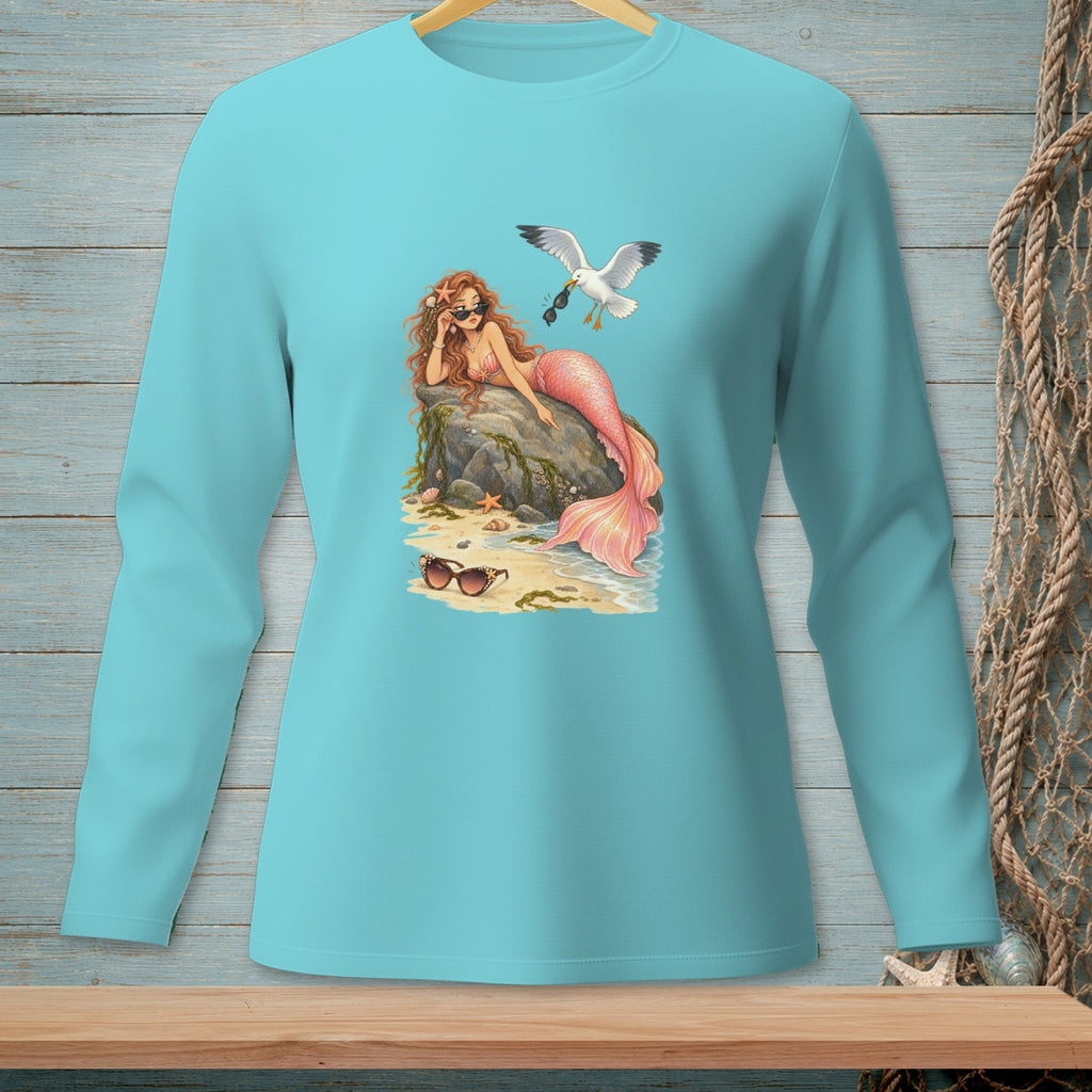 Mermaid with pink tail wearing sunglasses, sitting on a rock, with a seagull overhead.