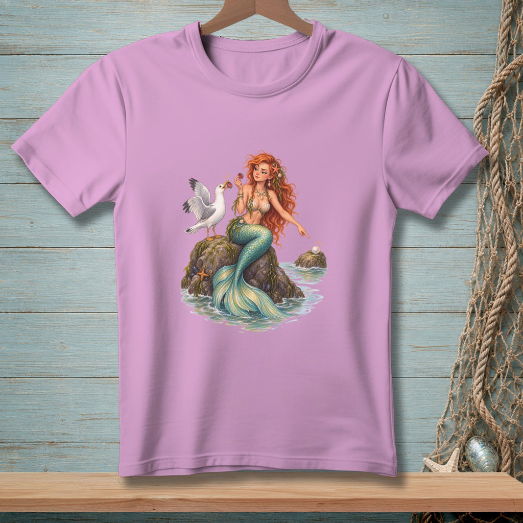 Pink t-shirt with a cartoon mermaid, seagull, and pearl on rocks.