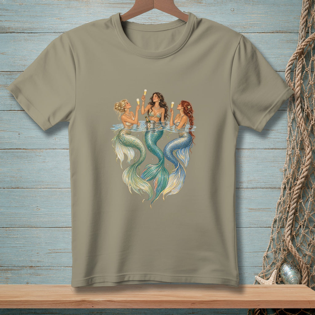 Three mermaids in water raise champagne glasses, their tails shimmering.