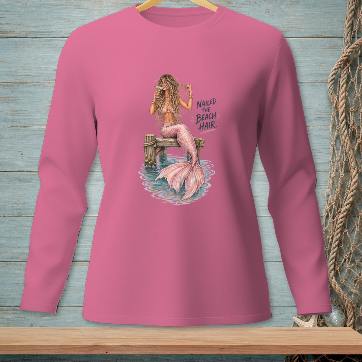 Pink long-sleeve shirt with a mermaid graphic and the text "Nailed the Beach Hair."