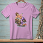 Lavender t-shirt with a mermaid lounging on rocks holding a drink.