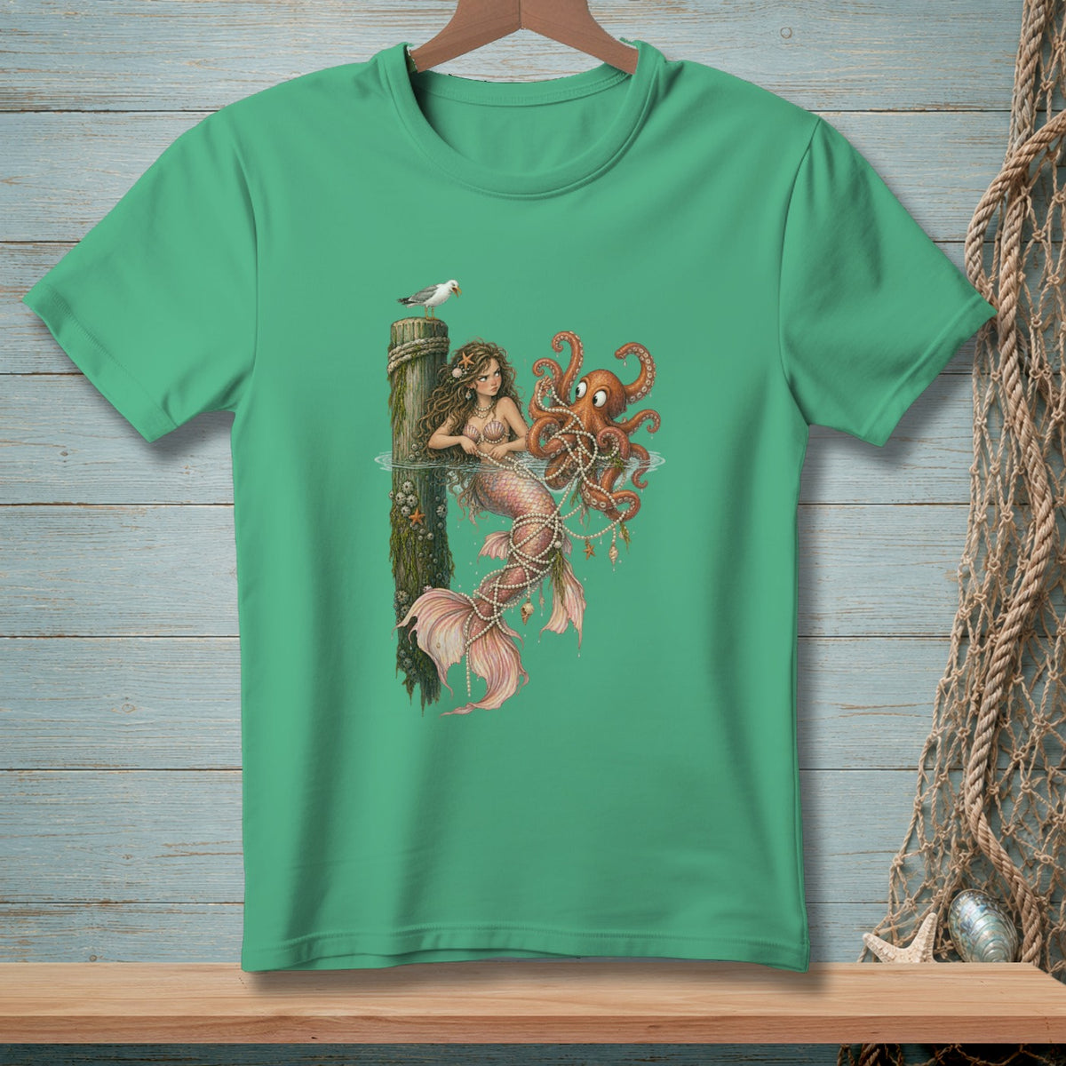Mermaid and octopus entangled in pearls on a green t-shirt.