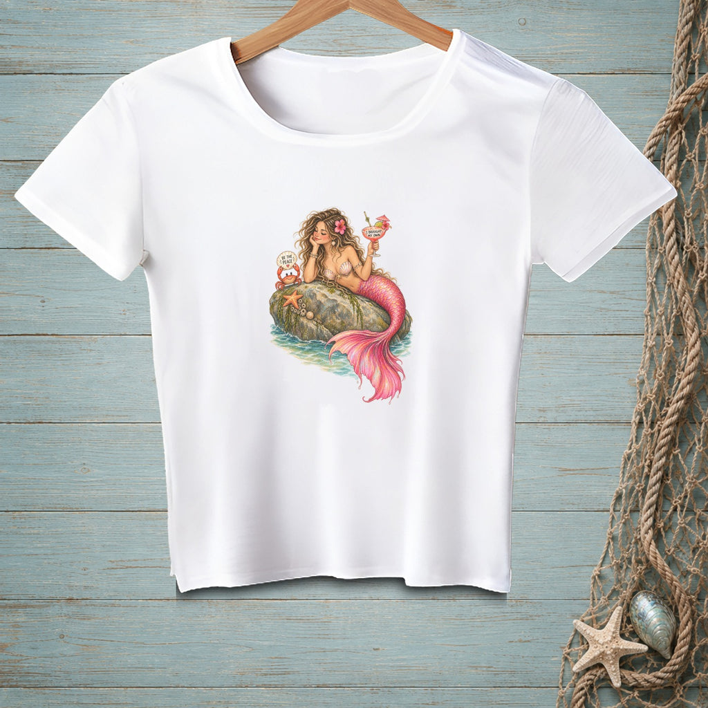 White t-shirt with a drawing of a mermaid and crab with a drink.