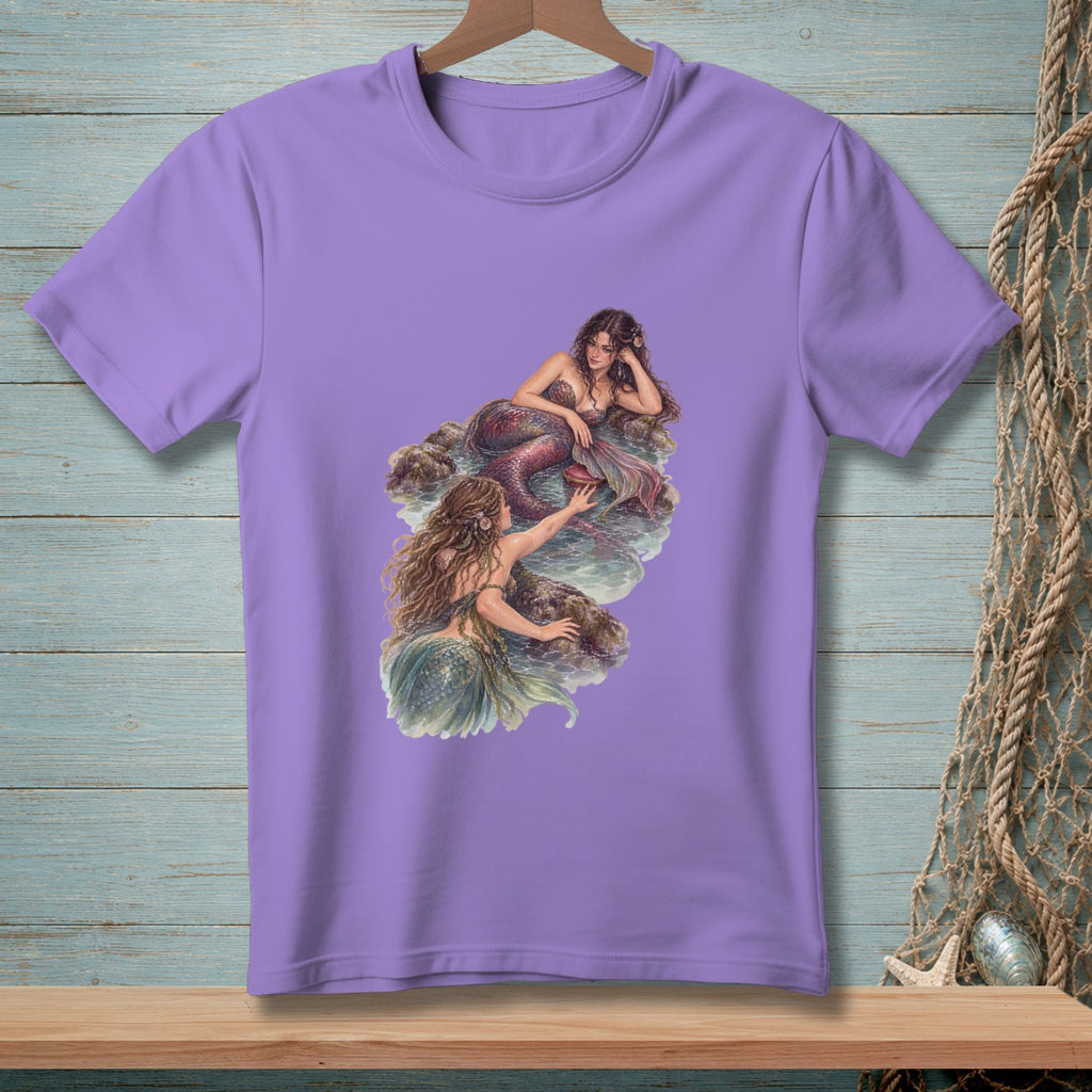 Purple t-shirt with a print of two mermaids sitting on rocks in the water.