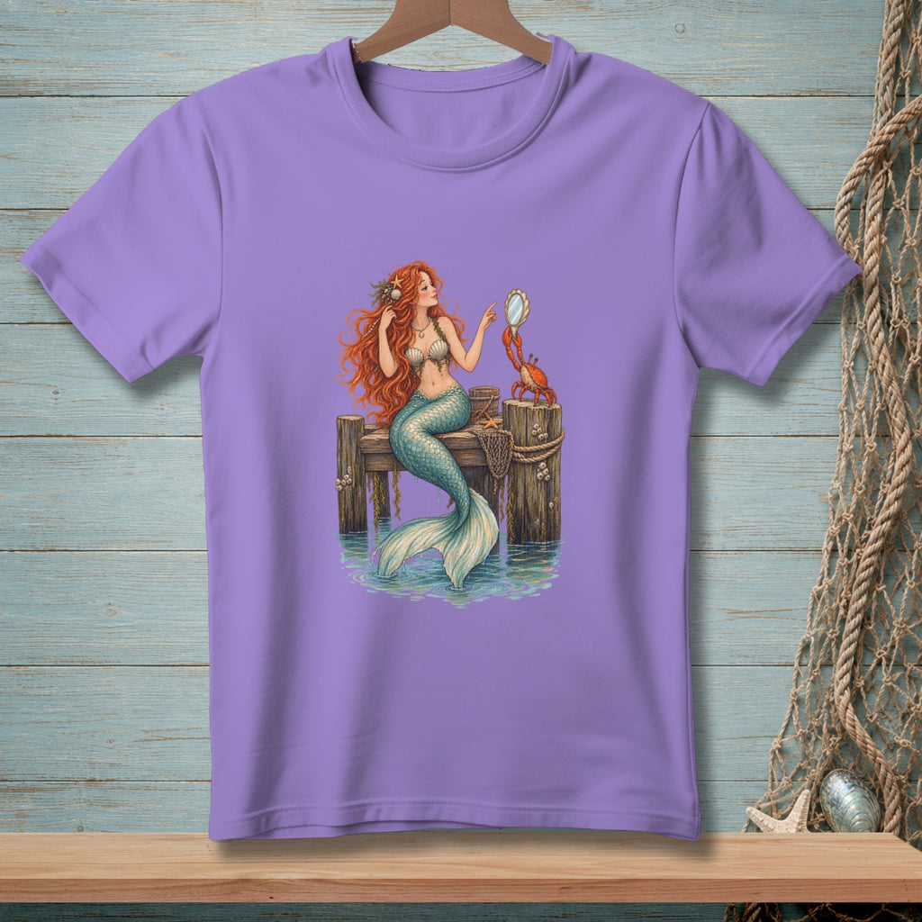 Purple t-shirt with a mermaid and crab on a wooden dock.
