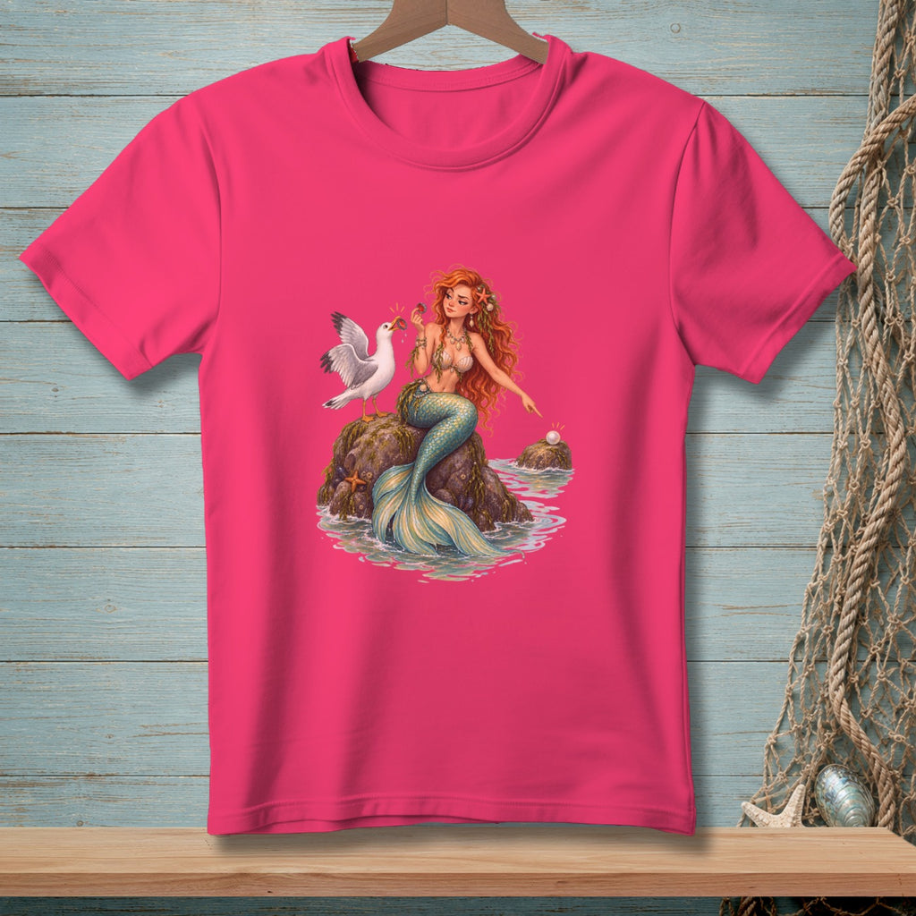 Pink t-shirt with a cartoon mermaid and seagull on a rock.