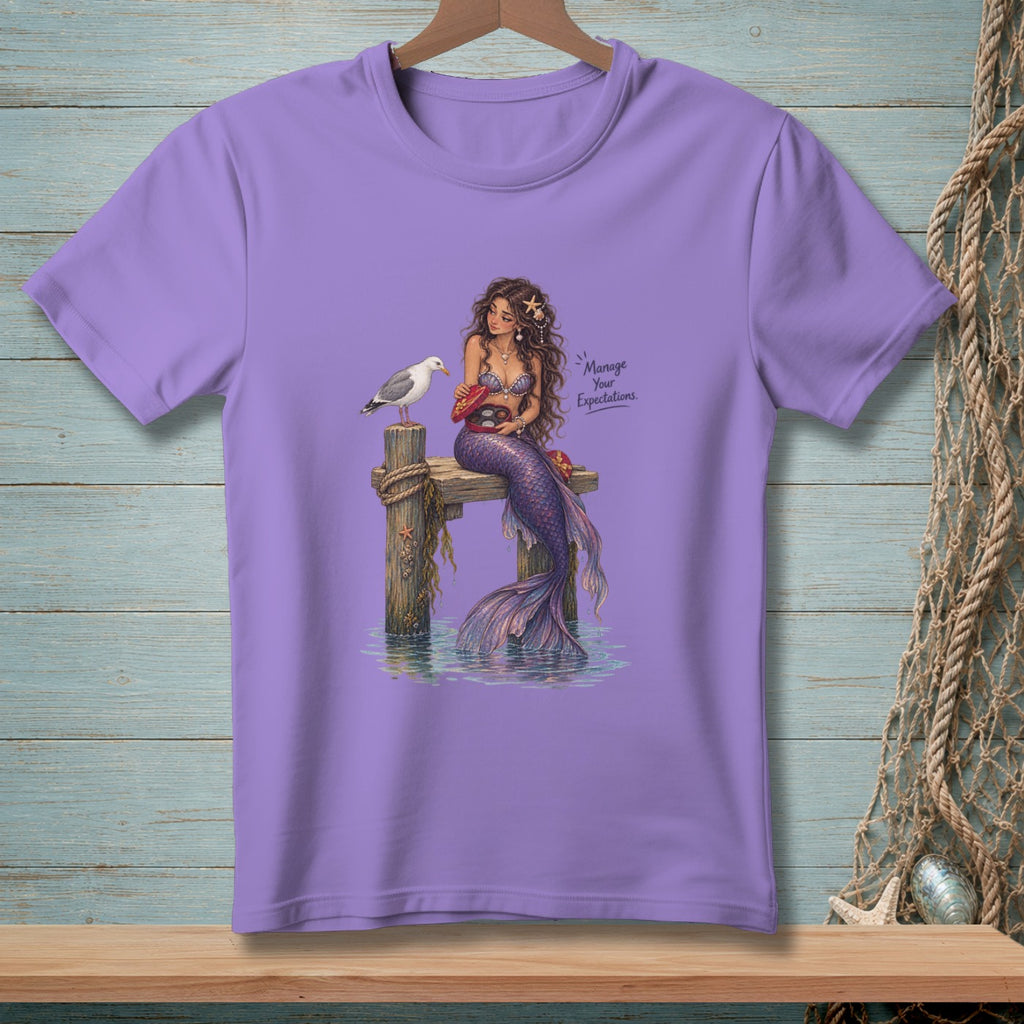 Purple t-shirt with illustration of a mermaid, seagull, and text "Manage Your Expectations."