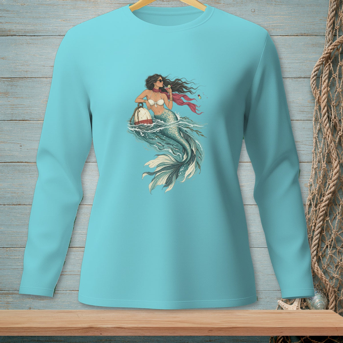 Mermaid with a buoy and drink on a light blue long-sleeved shirt.