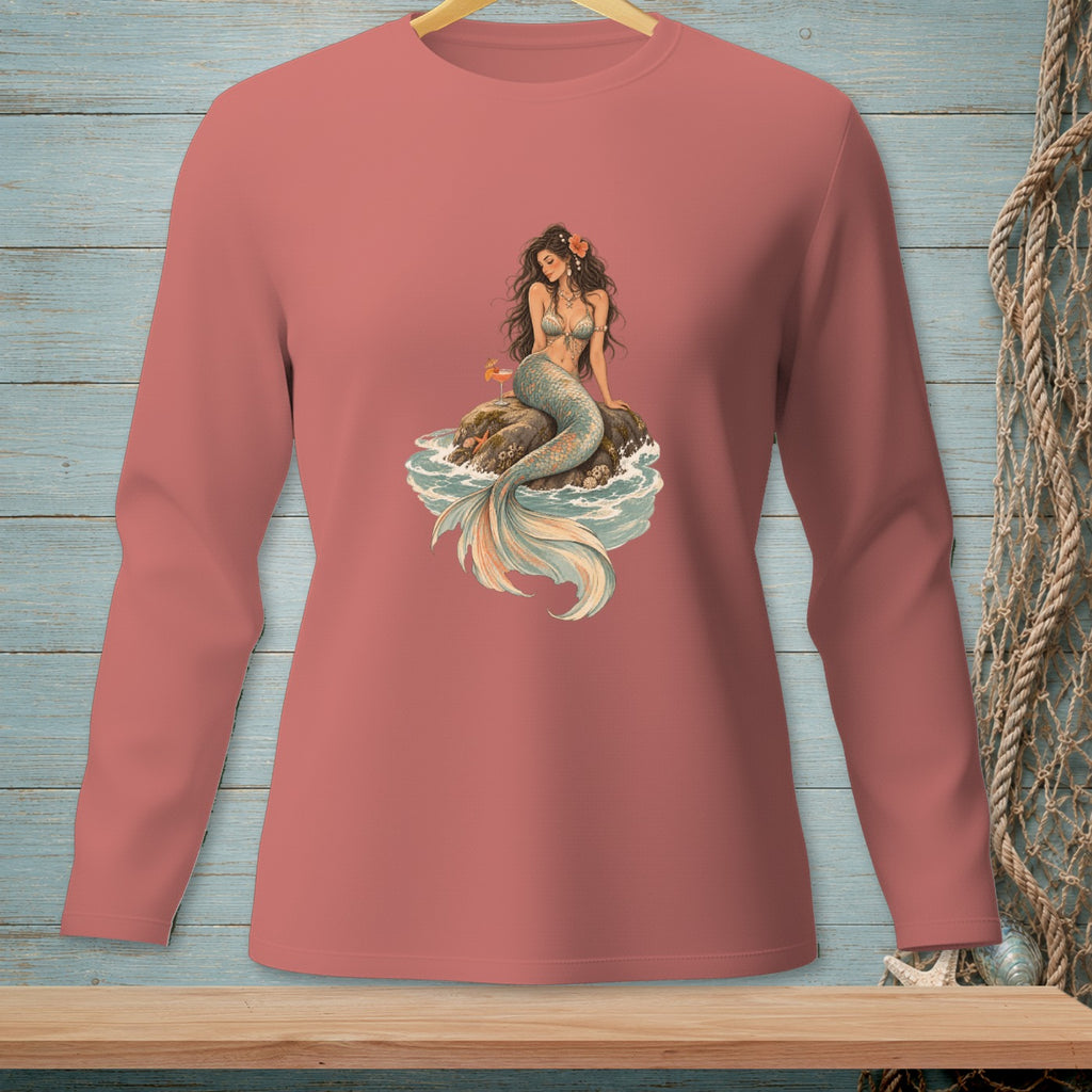 Mermaid with drink sitting on rock in the ocean.