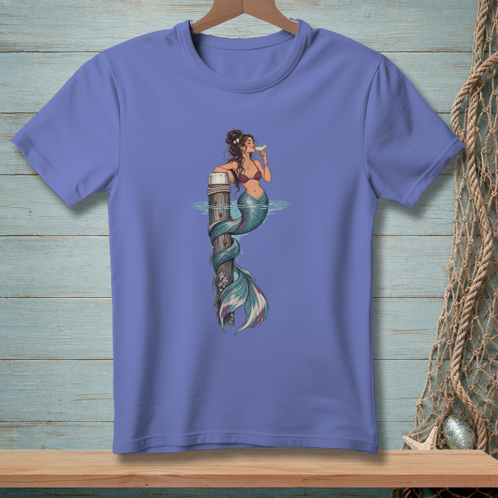 T-shirt with graphic of a mermaid with a tail wrapped around a wooden post, holding a drink.