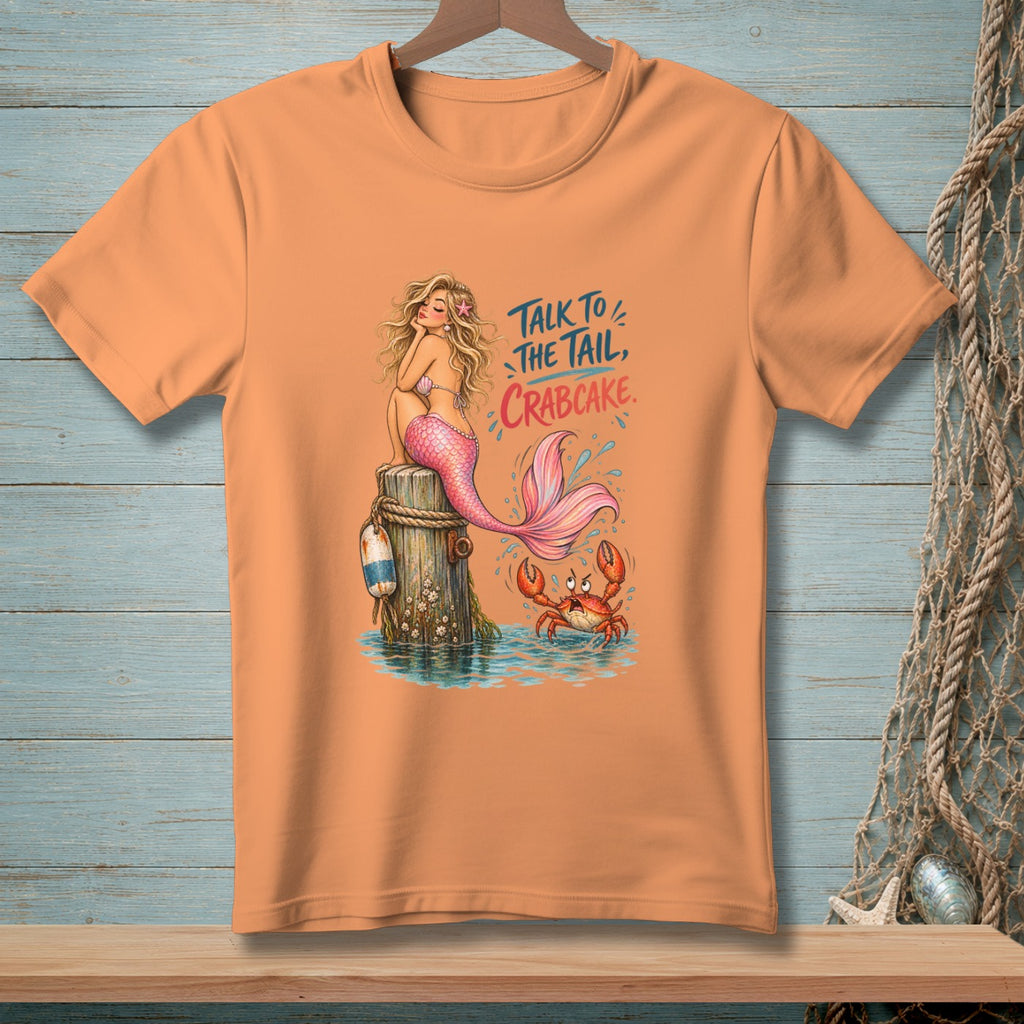 Peach t-shirt with mermaid and crab graphic, reading "Talk to the tail, crabcake."