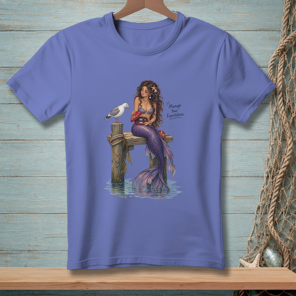 Mermaid with a seagull and chocolates on a dock, with text "Manage Your Expectations".