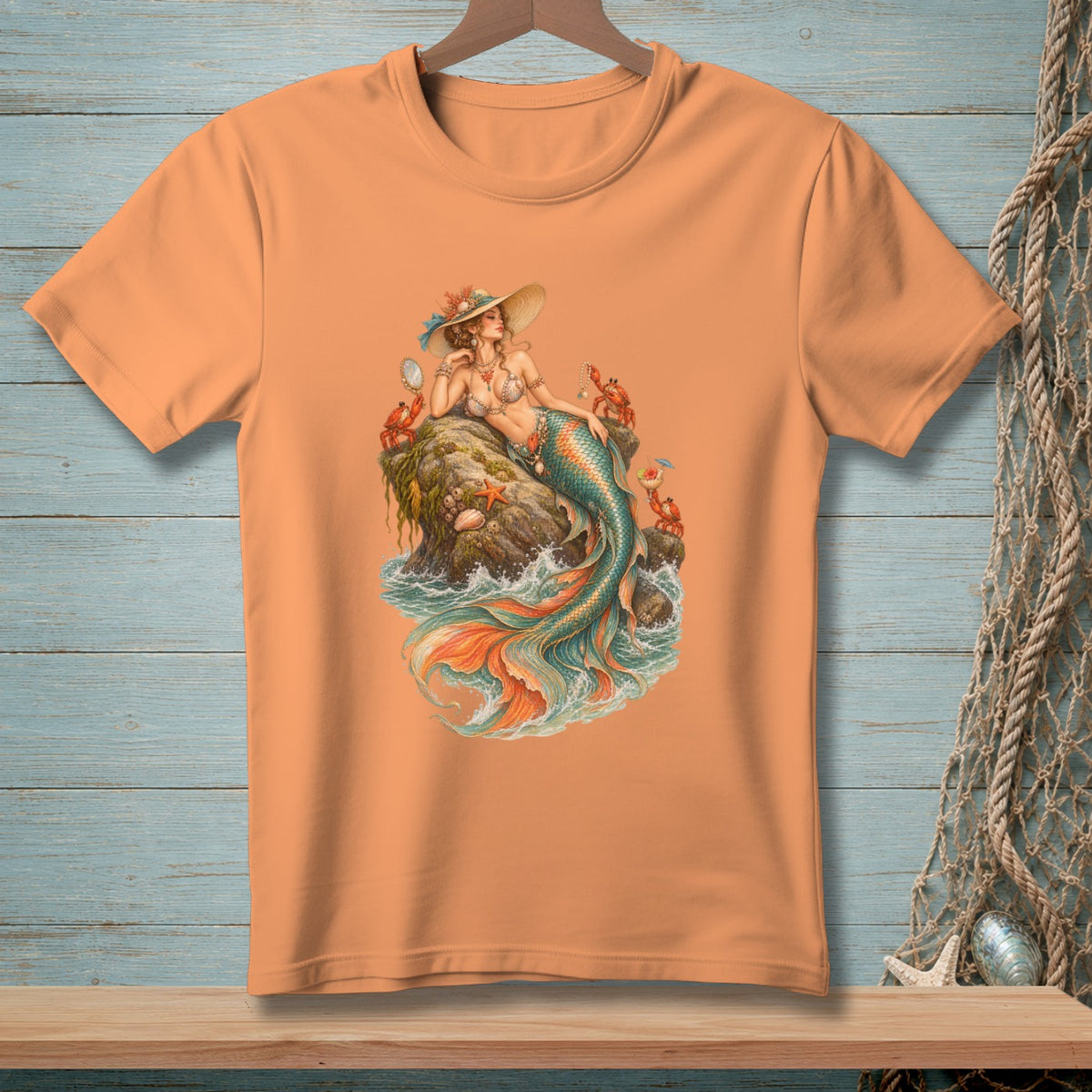 Illustration of a mermaid on a rock with crabs and starfish, on an orange t-shirt.
