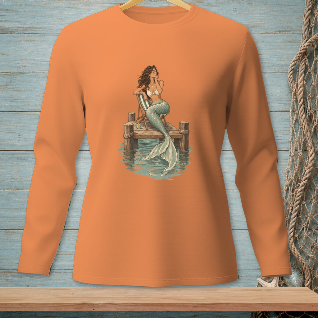 Mermaid with a tail sits on a pier, relaxing by the water.