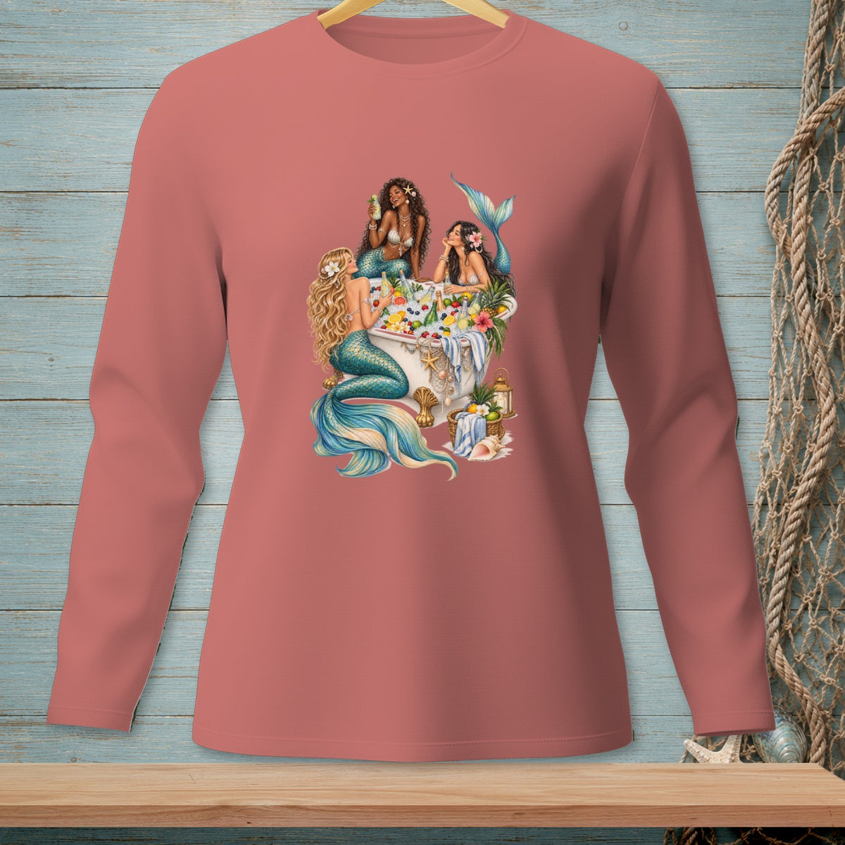 Three mermaids in a bathtub filled with fruit and flowers.