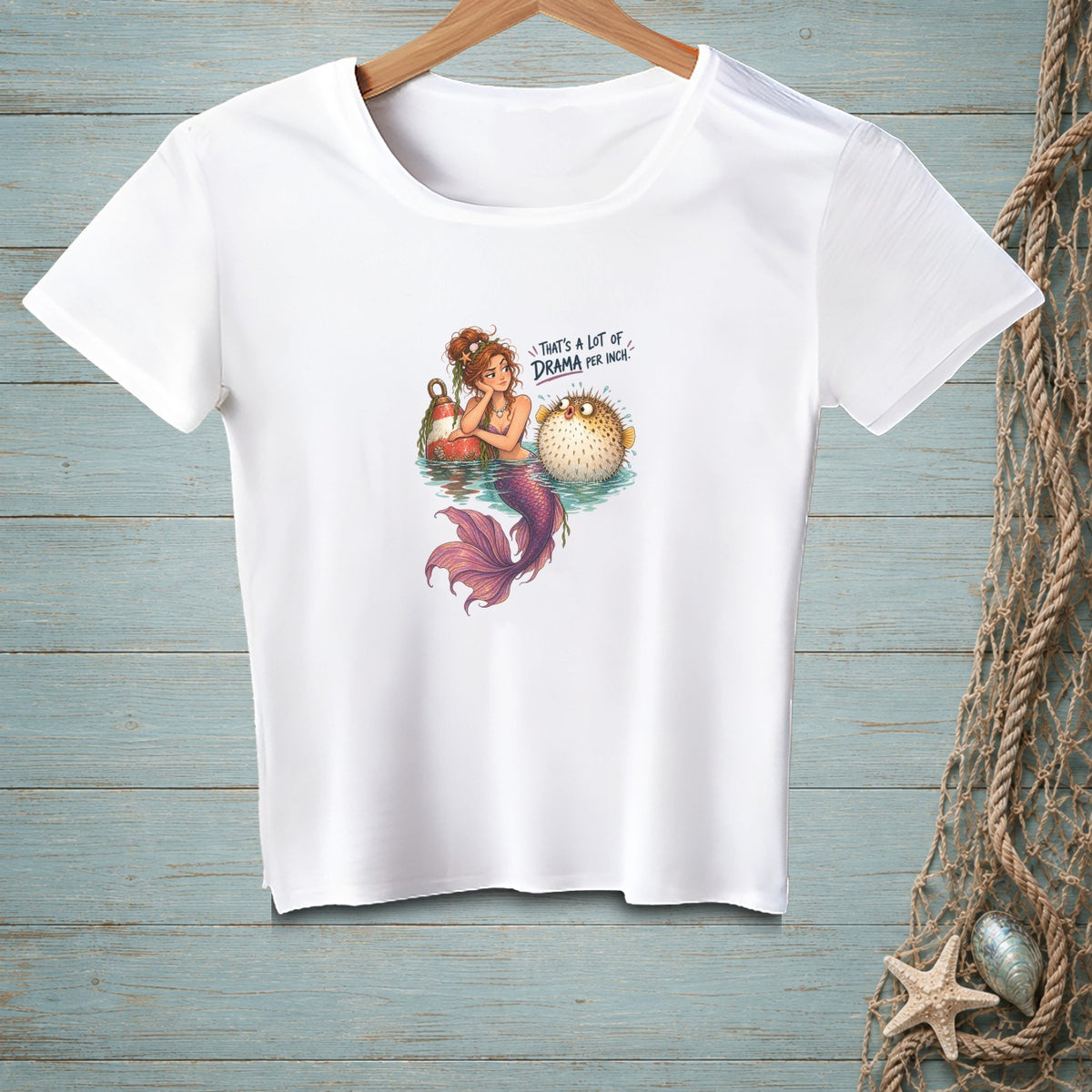 White t-shirt with a mermaid and pufferfish graphic and text.