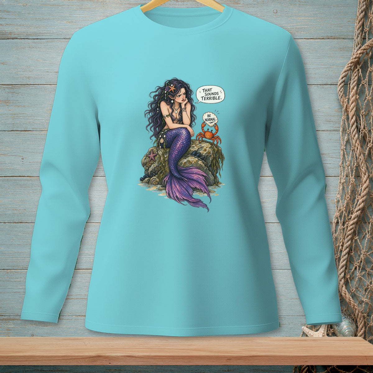 Teal long-sleeve shirt with a mermaid and crab graphic and dialogue bubbles.