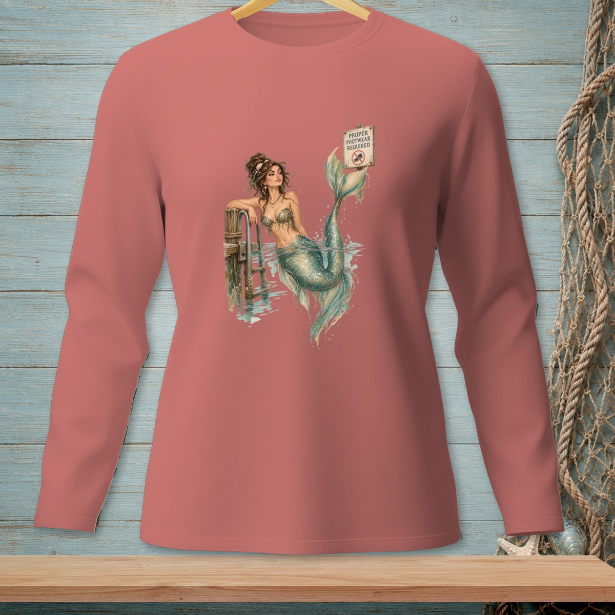 Long-sleeve shirt with a mermaid on a dock and a "Proper Footwear Required" sign.