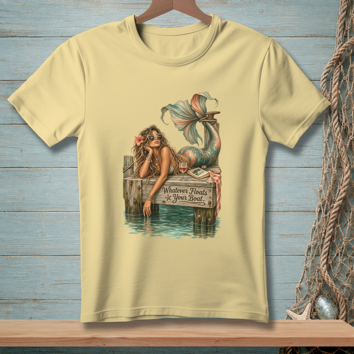 Mermaid with sunglasses and tail resting on dock, text reads "Whatever Floats Your Boat."